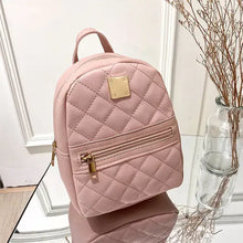 Load image into Gallery viewer, Pink quilted mini backpack for women made from PU leather, featuring a zipper pocket and gold-tone accents, styled on a mirrored surface.