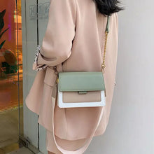 Load image into Gallery viewer, Woman wearing a stylish green and white leather crossbody bag for shopping, paired with a beige coat.