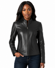 Cargar imagen en el visor de la galería, A woman modeling a black real-leather jacket with a full zip front, stand-up collar, and zippered side pockets, paired with dark blue jeans against a plain white background.