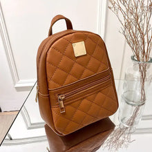 Load image into Gallery viewer, Brown PU leather mini backpack with gold zipper on glass table, featuring quilted design and versatile crossbody strap.