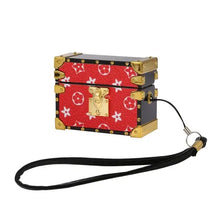 Cargar imagen en el visor de la galería, Luxury red and black mini trunk AirPods case with gold accents and detachable strap.