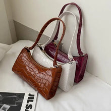 Cargar imagen en el visor de la galería, Elegant vegan leather shoulder bags in brown, white, and purple displayed on a bed, highlighting style and versatility.
