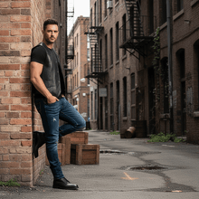 Load image into Gallery viewer, Man wearing REED Men's Soft Durable Motorcycle Leather Vest Black, 2 Inside Pockets - Imported, standing in an urban alley.