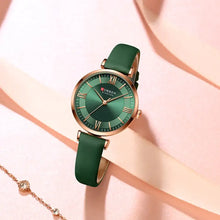Load image into Gallery viewer, Classic Clock Leather Watch with green leather strap and rose gold accents on pink background, perfect fashionable accessory for women.