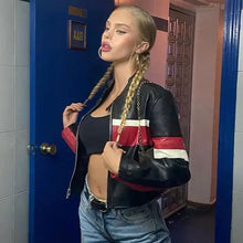 Charger l'image dans la galerie, Woman wearing a patchwork vegan leather jacket with red and white stripes, styled with jeans, standing confidently indoors.