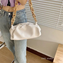 Load image into Gallery viewer, Woman holding a soft leather cloud bag with a gold chain strap, perfect for day to night style.