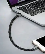 Cargar imagen en el visor de la galería, USB leather braided bracelet charging a smartphone from a laptop