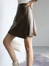 Load image into Gallery viewer, Woman wearing high-waist PU leather A-line split skirt in dark brown, showing side profile with chic and trendy style.