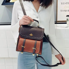 Load image into Gallery viewer, Woman holding stylish vintage paneled PU leather backpack in brown and black, perfect for fashion-forward explorers. Vegan leather.
