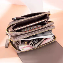 Load image into Gallery viewer, Open leather shoulder bag displaying organized compartments with phone, pen, cash, and keys inside.