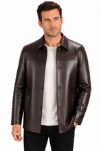 Charger l'image dans la galerie, A man wearing a dark brown leather jacket over a white t-shirt and black pants, photographed against a plain white background.