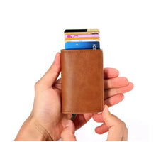 Load image into Gallery viewer, Person holding a brown vegan leather anti-theft wallet with RFID/NFC protection, showing multiple cards inside.