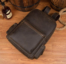 Load image into Gallery viewer, The Langley Backpack | Genuine Vintage Leather Backpack on wood floor, showcasing premium craftsmanship and functionality.
