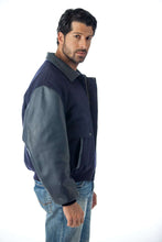 Load image into Gallery viewer, REED men's leather varsity bomber jacket, made in USA, featuring top-grain leather sleeves and trim, modeled by a man in jeans.