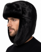 Load image into Gallery viewer, A man wearing a black faux fur ushanka winter hat, shown in profile against a plain white background.