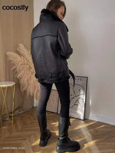 Load image into Gallery viewer, Woman wearing a high-quality faux leather fur coat, showcasing a chic and elegant winter fashion look, in a room with modern decor.