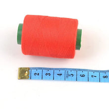 Load image into Gallery viewer, Spool of red sewing thread next to a measuring tape, part of the eZthings Professional Sewing Thread Kit for arts and crafts.