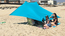 Load image into Gallery viewer, Family enjoying shade under eZthings UV Light Sun Shade Protection Beach Shelter with sandbag anchors on a sunny beach.