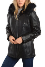 Load image into Gallery viewer, Woman wearing a black leather jacket with fox trimmed hood and braided leather details, perfect for winter fashion.

