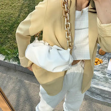Load image into Gallery viewer, Woman wearing stylish outfit with a soft leather cloud bag featuring a gold chain, emphasizing luxury and versatility.
