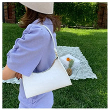 Load image into Gallery viewer, Woman wearing a crocodile pattern PU leather white shoulder bag in an outdoor setting with greenery and a picnic blanket in the background.
