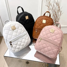 Load image into Gallery viewer, Quilted mini backpacks in white, black, brown, and pink vegan leather with gold-tone accents, displayed on a mirrored surface.
