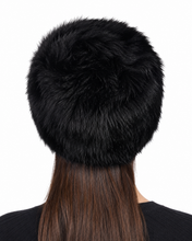 Charger l'image dans la galerie, A black faux fur beanie hat shown from the back on a model with long brown hair, against a plain white background.
