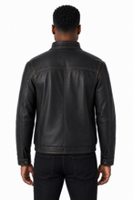Cargar imagen en el visor de la galería, A man viewed from the back wearing a black leather jacket and black jeans against a plain white background.
