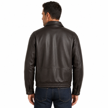 Load image into Gallery viewer, A man viewed from the back wearing a dark brown leather jacket and dark blue jeans, set against a plain white background.
