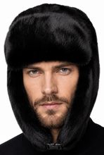 Load image into Gallery viewer, A man wearing a black fur ushanka hat with ear flaps and a black knit sweater, shown against a plain white background.
