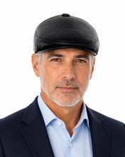 Load image into Gallery viewer, A man wearing a black leather-like flat cap, a light blue dress shirt, and a dark navy blazer, photographed against a plain white background.
