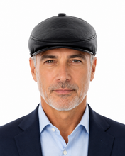 Load image into Gallery viewer, A man wearing a black leather flat cap, a light blue dress shirt, and a dark navy blazer, photographed against a solid white background.
