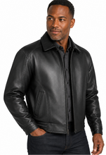 Charger l'image dans la galerie, A man wearing a black leather jacket over a black button-down shirt, photographed against a plain white studio background.
