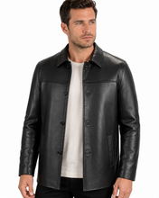 Charger l'image dans la galerie, A man wearing a black leather jacket over a light beige t-shirt, photographed against a solid white background.
