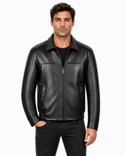 Charger l'image dans la galerie, A man wearing a black leather jacket with a front zipper, collar, and zippered hand pockets, paired with black jeans, against a plain white background.
