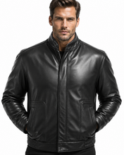Load image into Gallery viewer, A man wearing a black leather jacket with a stand-up collar, front zipper, and two front patch pockets, photographed against a plain white background.
