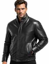 Load image into Gallery viewer, A man wearing a black leather jacket with a stand-up collar, front zipper, and zippered chest pockets, photographed against a plain white background.
