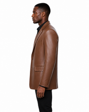 Charger l'image dans la galerie, A man wearing a brown real -leather blazer over a black collared shirt and black pants, standing against a plain white background.
