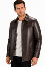 Charger l'image dans la galerie, A man wearing a dark brown leather jacket over a light gray t-shirt and black pants, photographed against a plain white studio background.
