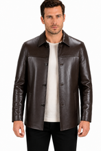 Charger l'image dans la galerie, A man wearing a dark brown leather jacket over a white t-shirt and black pants, photographed against a plain white background.
