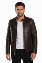Load image into Gallery viewer, A man wearing a dark brown leather motorcycle jacket over a white t-shirt and black pants, standing against a plain white background.
