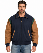 Load image into Gallery viewer, A man wearing a navy blue and brown color-blocked zip-up jacket with green shoulder panels, paired with blue jeans, against a plain white background.
