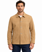 Charger l'image dans la galerie, A man wearing a tan suede-like button-front jacket over a white shirt and dark blue jeans, photographed against a plain white studio background.
