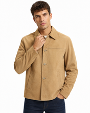 Charger l'image dans la galerie, A man wearing a tan suede-like button-up jacket with a collar, front pockets, and dark blue jeans, photographed against a plain white background.
