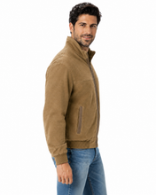 Load image into Gallery viewer, A man wearing a tan suede zip-up jacket and blue jeans, shown from a side profile against a plain white background.
