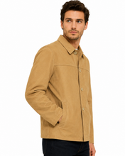 Charger l'image dans la galerie, A man wearing a tan utility jacket with a button-up front and chest pockets, paired with dark pants, photographed against a plain white background.
