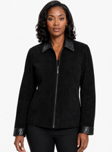Charger l'image dans la galerie, A woman modeling a black zip-front jacket with black real-leather trim on the collar, cuffs, and hem, photographed against a plain light gray studio background.

