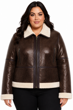 Cargar imagen en el visor de la galería, A woman modeling a brown real-croc leather aviator jacket with a cream-colored shearling collar, hem, and cuffs, paired with black pants against a white studio background.

