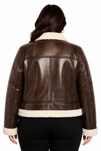 Cargar imagen en el visor de la galería, A woman viewed from the back wearing a brown textured real-leather jacket with cream shearling-style collar, hem, and cuffs, paired with black pants against a plain white background.
