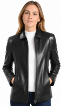 Cargar imagen en el visor de la galería, A woman wearing a black real leather jacket over a white top and dark blue jeans, photographed against a plain white background.
